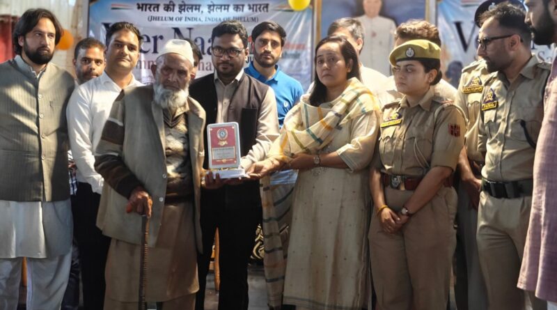 An emotional close-up of Annu Pasricha of Khaki Association honoring a senior Kashmiri Muslim martyr's mother in Handwara, Kupwara. She holds a traditional shawl and a certificate, tears of dignity visible.